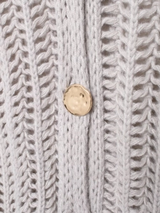 Dettaglio della maglia spessa grigio chiaro con un bottone rotondo dorato strutturato