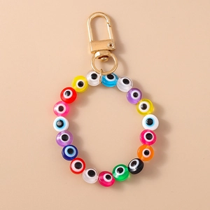 Detail of colorful resin evil eye beads and gold lobster clasp on trendy keychain