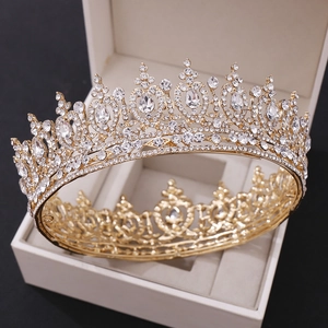 Detail of a gold baroque bridal crown featuring sparkling rhinestones on a jewelry box