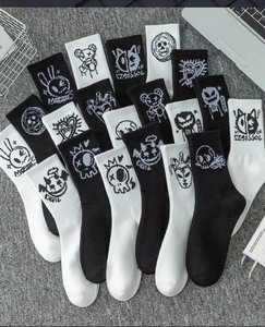 Detail of crew socks featuring street-style skull and devil prints on black and white cotton