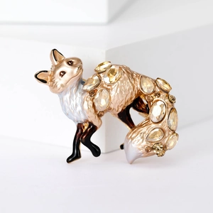 Detailed view of fox brooch with gold alloy, yellow crystal and enamel finish