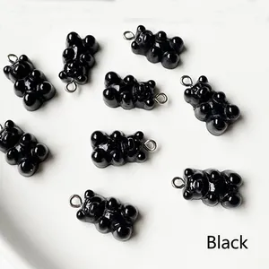 Macro view of black resin gummy bear pendants with metal loops for DIY jewelry making