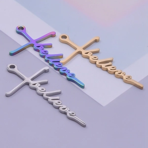 Close-up of three 304 stainless steel 'believe' cross pendants in gold, silver, and rainbow
