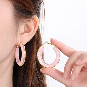 Pink resin hoop earrings with gold trim shown on model for a trendy summer look