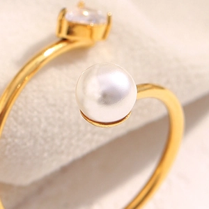 Macro detail of 18K gold-plated snake ring featuring a white pearl and square zircon