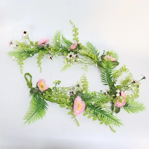 Detailed view of pink silk flowers and green foliage vines for wedding arch decoration