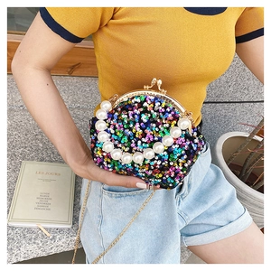 Detail of colorful sequin shell bag with large pearl handle and metal chain strap