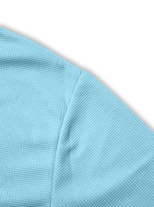 Detailed close-up of light blue waffle knit texture and stitching on men's polo shirt