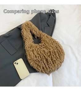 Size comparison between a smartphone and a plush faux fur tote bag in camel color