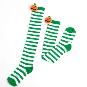Detail of green and white striped Halloween socks with 3D pumpkin ornaments
