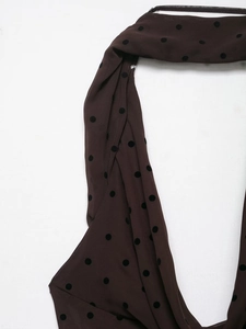 Macro view of brown polka dot dress fabric with textured velvet flocking detail