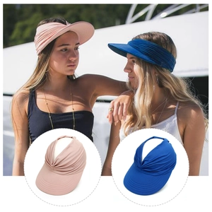 Detail of pink and navy sun visors featuring elastic pleated knit fabric and wide brims