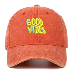 Close-up of GOOD VIBES embroidery detail on washed orange cotton baseball cap