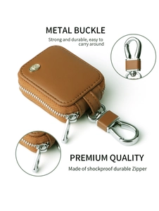 Detail view of brown leather case for AirPods featuring a metal buckle and durable zipper