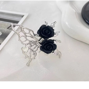 Detail shot of hollow butterfly wings with black roses on a silver adjustable ring