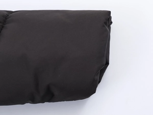 Detailed close-up showing the smooth black fabric and texture of the oversized padded jacket