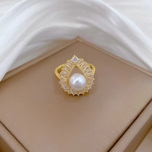 Macro detail of luxury teardrop pearl ring with sparkling zircon in gold plating