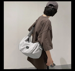 Detailed view of gray large capacity fitness bag with nylon texture on female model