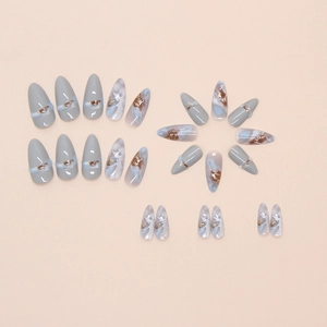 Almond-shaped press-on nails featuring marble textures in grey, blue, and amber gold foil