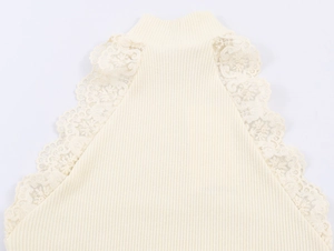 Dettaglio della maglia a coste bianco avorio e del bordo in pizzo sullo scollo