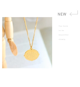 Vue détaillée d'un collier pendentif pièce vintage doré avec un porte-bonheur en relief