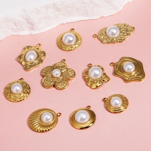 Pendentifs en acier doré en forme de fleur et cœur avec perles sur fond rose