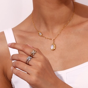 Eleganz-Set mit X-förmigen Kristallringen und Goldhalskette mit weißem Anhänger