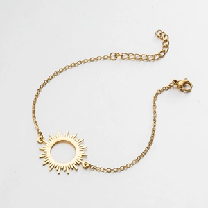 Detail of gold chain bracelet with sunburst pendant, lobster clasp and extension chain
