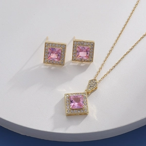 Detail of pink crystal necklace and earrings set with zircons on a marble stand