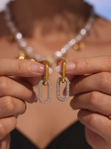 Gros plan de boucles d'oreilles ovales plaquées or avec micro-pavage en zircons et design amovible