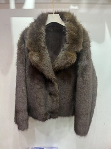 Détail d'une veste en fausse fourrure marron café avec des manches longues et col à revers