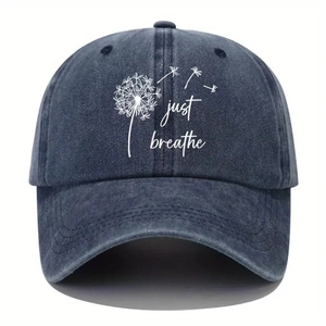 Washed navy baseball cap with white dandelion print and 'Just Breathe' text