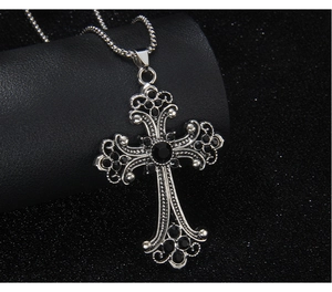 Macro shot of silver hip-hop cross pendant featuring intricate black gemstone inlay work