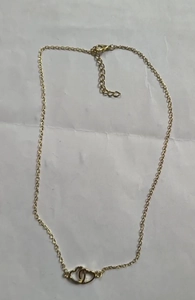 Detail shot of interlocking double heart pendant in golden finish on a fine chain