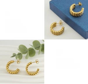 Detailed macro view of 18k gold plated twisted C-shape hoop earrings with polished finish