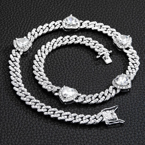 Detail of silver cuban chain necklace and bracelet with rhinestones and heart gems