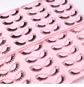 Detailed view of five pairs of cat-eye false eyelashes on a pink tray with clear bands