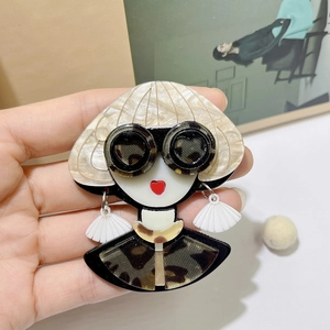 Detail of acrylic fashion girl brooch with leopard print sunglasses and red lips design