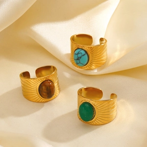 Golden wide geometric rings with turquoise and tiger eye stones on beige silk