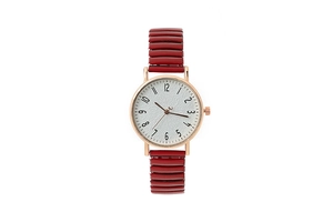 Detail of red metal stretch band watch with rose gold case and white numeric dial
