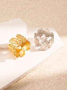 Detailed macro view of ginkgo leaf set rings in gold and silver on stone