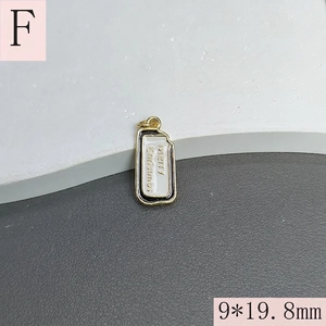 Detail of 9x19.8mm Merry Christmas pendant with gold plating and white enamel inlay