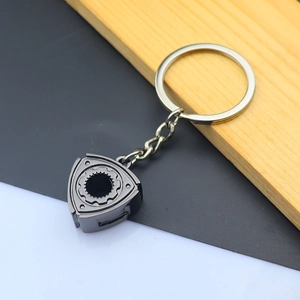 Macro detail of gunmetal zinc alloy rotor engine keychain with flat key ring