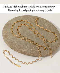 Detailed macro view of gold-plated stainless steel twist chain with S.STEEL logo tag