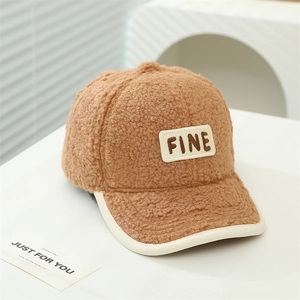 Détail de la casquette en polaire bouclée marron pour enfant avec écusson brodé FINE