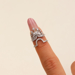 Detail of silver nail ring set with zircon snowflake and curved minimalist band