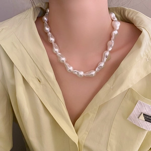 Dettaglio della collana di perle barocche irregolari portata con eleganza sul collo