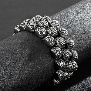 Detailed macro view of vintage silver steel bracelet with ornate engraved square beads