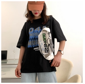 Détail de la sacoche transparente blanche en PVC avec pendentif en damier portée par un modèle