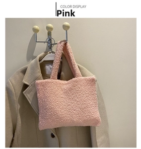 Detail showing plush pink faux fur texture of the handbag against a beige coat background